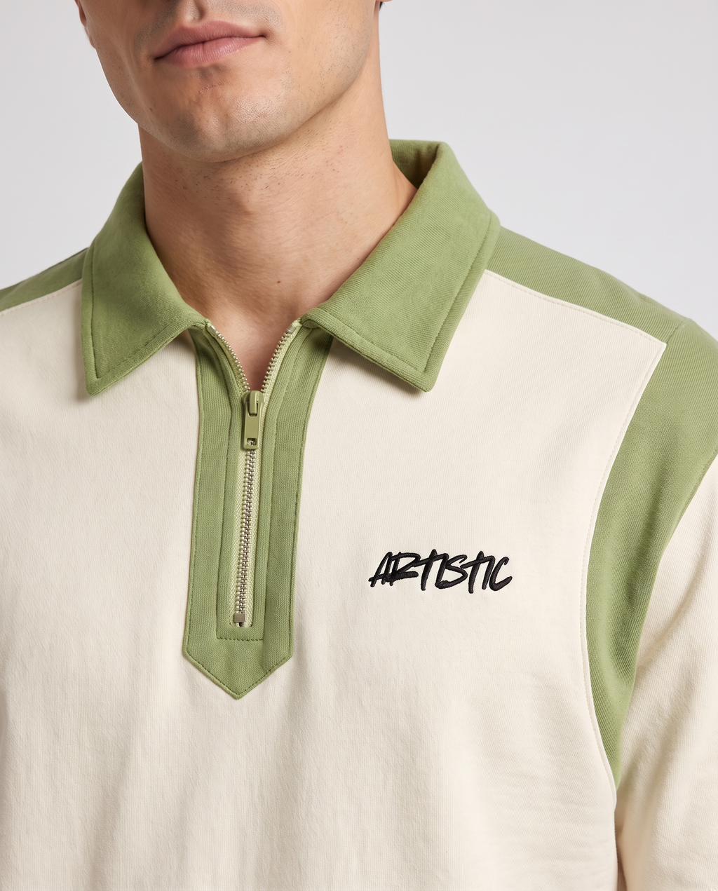 The Green Room zip polo — collar and logo detail